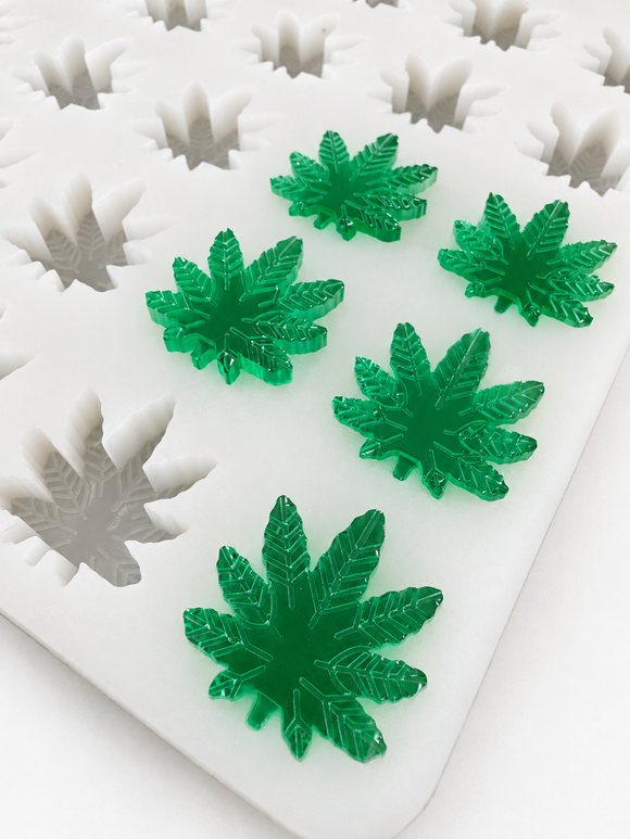 Close-up of 2.73mL cannabis leaf gummies in an emerald green finish on a commercial silicone gummy mold